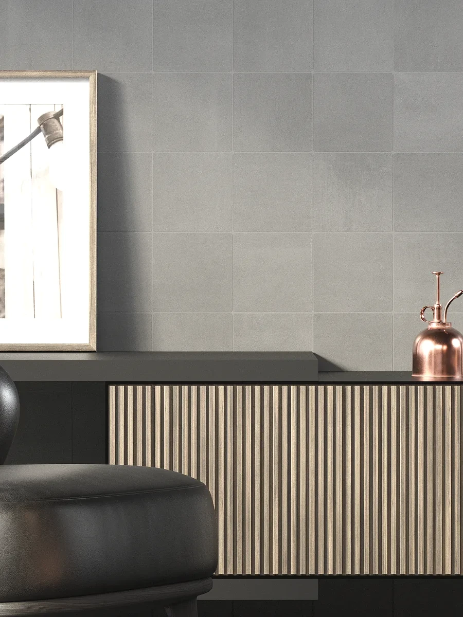 Pared de salón decorada con azulejo gris efecto cemento de diseño contemporáneo, ambiente de interiorismo con detalles en madera y cobre