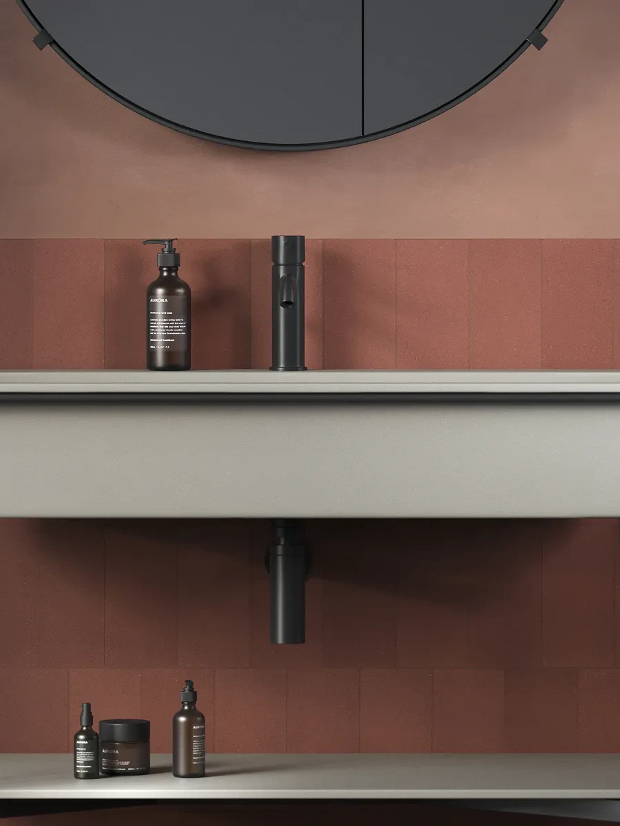 Pared de cuarto de baño con azulejos en color rojo terracota colocados a media altura y combinados con tonos tierra