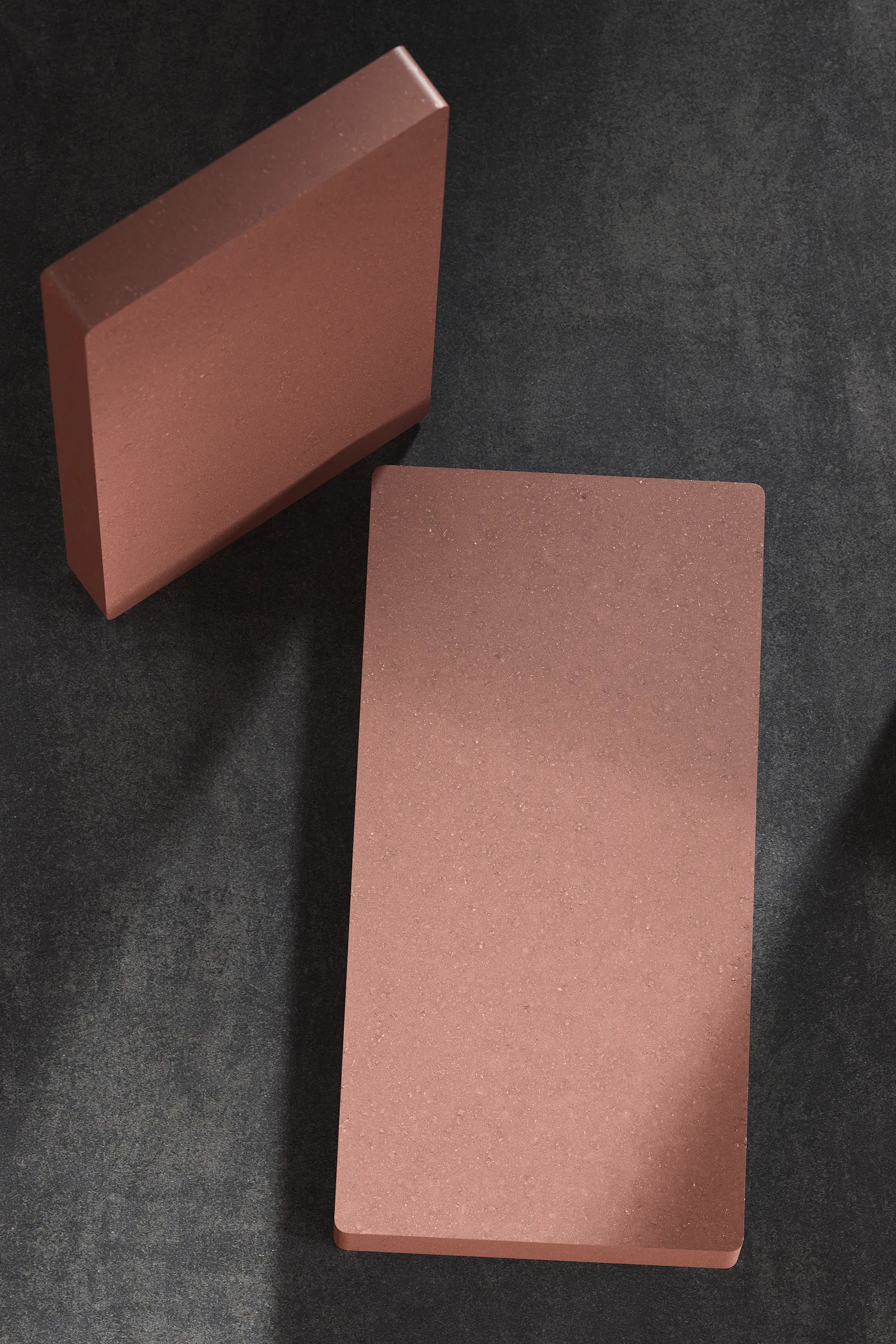 Photographie de carrelage rouge terracotta mettant en valeur le profil de la pièce et sa texture en détail