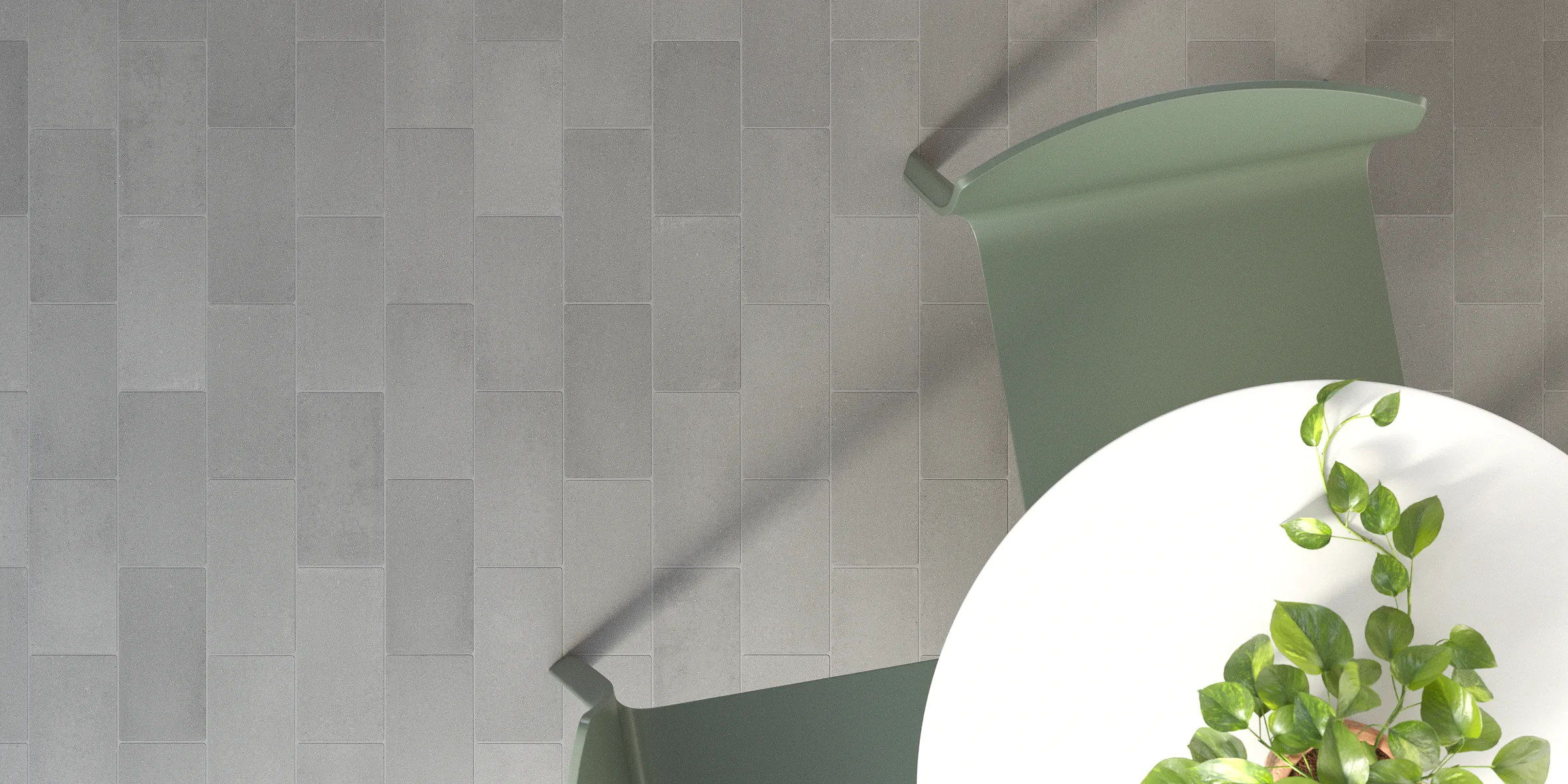 Pavage extérieur avec un pavé en béton gris de faible épaisseur posé en décalé, révélant les variations naturelles de tonalité du béton
